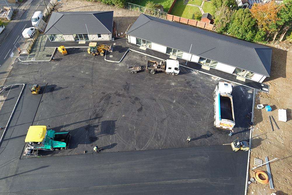 Drone shot of construction workers tarmacing carpark